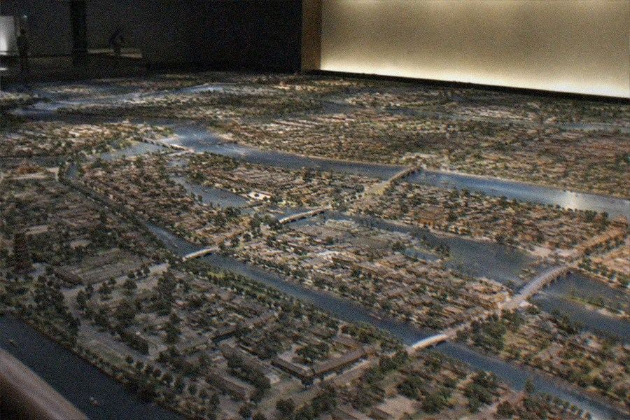 Visitors reading display panels about canal boats and grain transport in the Beijing Grand Canal Museum exhibition hall