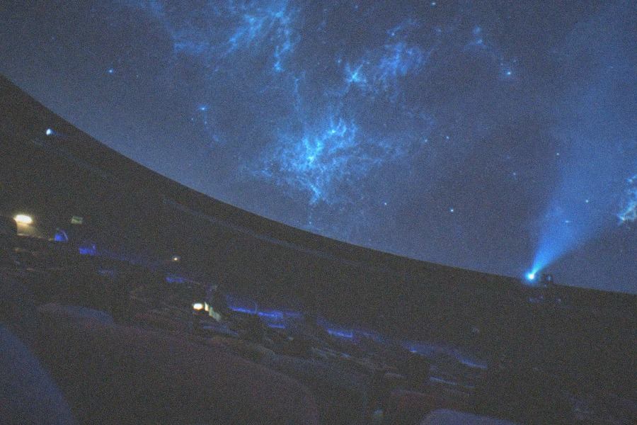 Night sky star projection filling the interior of a domed planetarium theater