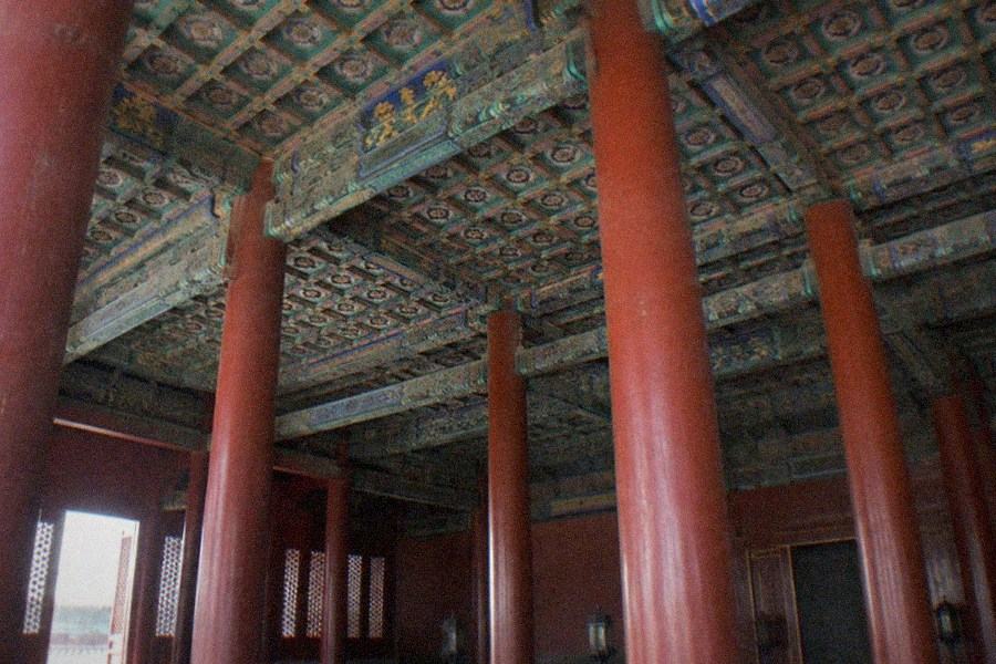 A quiet furnished hall with wooden furniture and display cases inside the Palace Museum