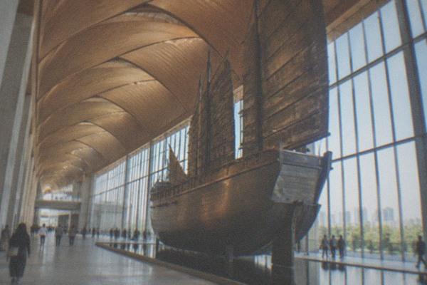 Modern museum building with a large canopy structure beside a waterway in Tongzhou, Beijing
