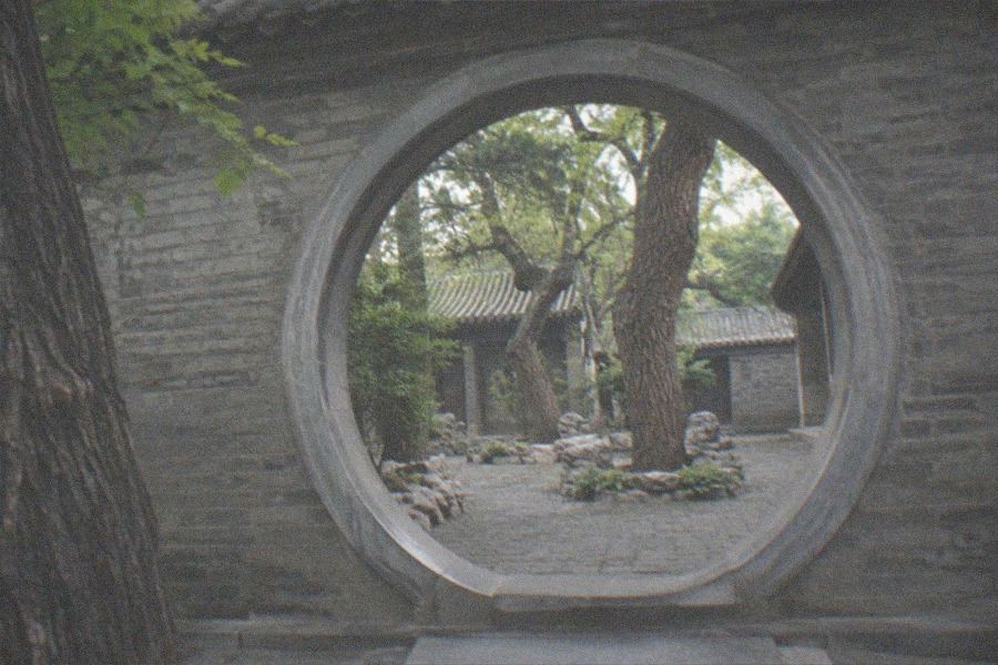 Furnished Qing dynasty hall interior with wooden furniture and hanging lanterns