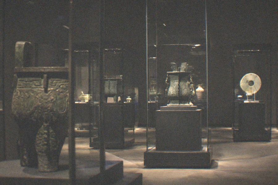 Museum corridor with tall windows and exhibits displayed behind glass