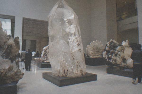 Mineral specimens displayed in glass cases inside a dimly lit museum gallery