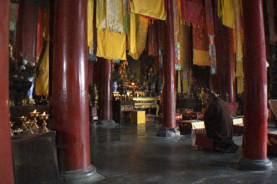 Courtyard of a Tibetan Buddhist temple with incense brazers and stone paving