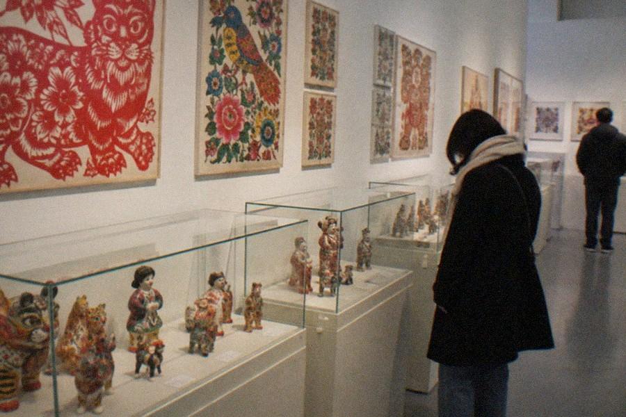Spacious gallery hall inside the National Art Museum of China with paintings hung along the walls