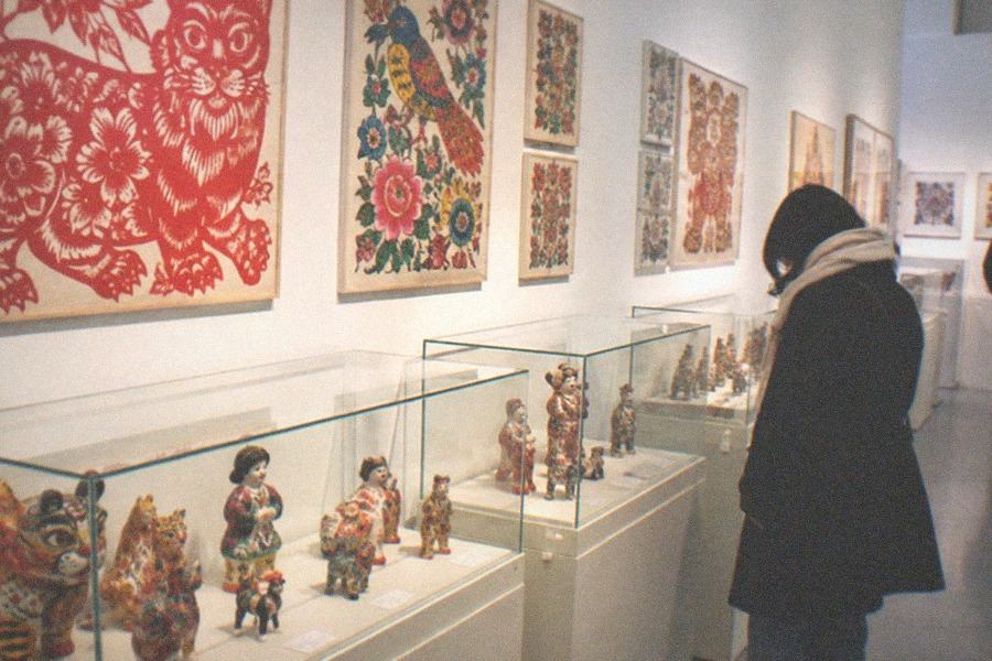 A classical hardwood chair displayed against a plain gallery wall