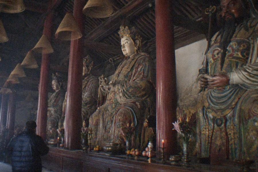 Rows of stone tablets standing along a paved temple courtyard