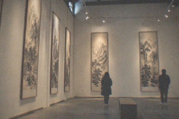 Gallery doorway in a converted factory building with a bright exhibition poster