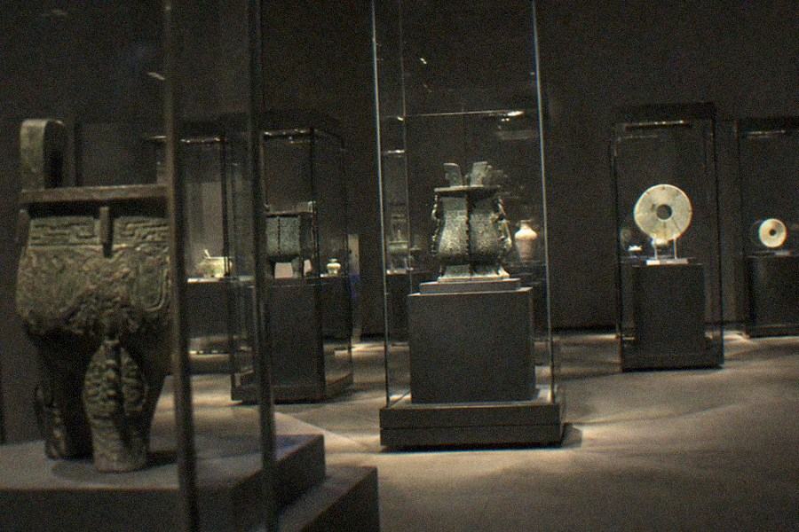 A museum gallery with glass display cases and soft overhead lighting