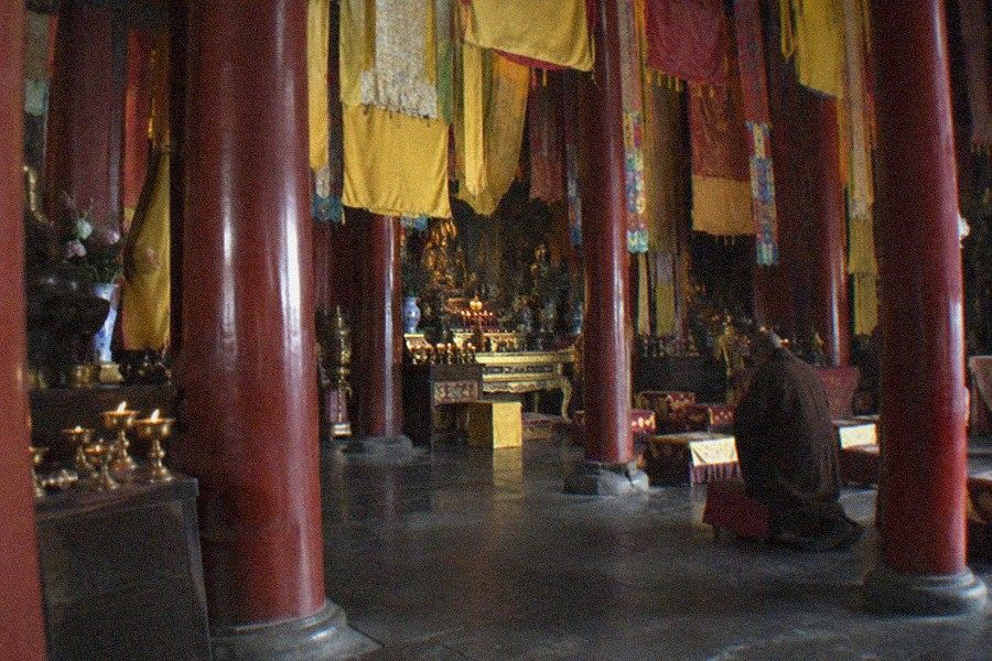 The Lama Temple (Yonghegong) main gate and forecourt with incense smoke rising over worshippers