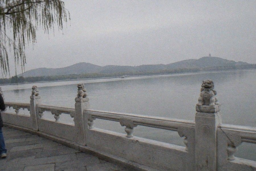 The Long Corridor of the Summer Palace stretching along Kunming Lake with painted beams and the Tower of Buddhist Incense rising on Longevity Hill behind