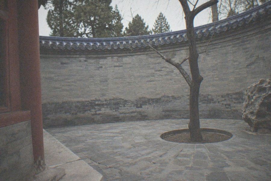 The Hall of Prayer for Good Harvests at the Temple of Heaven, a circular triple-tiered hall with a dark blue tiled roof, seen across an empty stone courtyard in early morning light