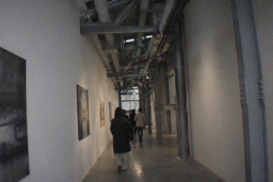 Visitors walking through a high-ceilinged exhibition hall with large suspended works at the UCCA Center for Contemporary Art